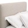 Close-up on the fabric texture and tight upholstery of the headboard corner near pillows