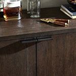 Close-up of sideboard top surface with wood grain and various bar accessories