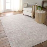 Rug placed in a living space with natural light, wood flooring, and beige armchair with side table