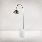 Floor lamp against light gray textured wall highlighting marble base and curved bronze arm