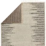Back side of Patra rug showing solid taupe wool with linear pile and cream fringe