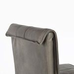 Zoomed view on rolled leather top edge of backrest revealing leather texture and stitch lines