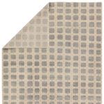 Rug flipped corner revealing the flat woven backside with muted gray and ivory geometric pattern