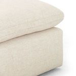 Macro detail of the lush, tightly woven cream fabric on the seat cushion with subtle stitching