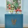 Single Longleaf Door Cabinet styled in muted blue room with fig artwork and decorative flamingos on top