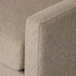 Close-up of top corner of armrest and seat cushion seam showcasing fabric texture and stitching