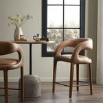 Hawkins bar stool styled in kitchen setting next to round wood table with decorative accessories