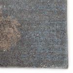 Close-up on section of rug showcasing dense pile with blue and taupe abstract pattern