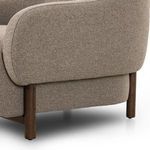 Close-up of back corner showing textured upholstery and rounded wooden legs