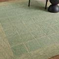 Close-up view showing the rug’s textured wool fibers and pattern near a chair and side table