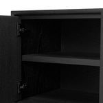 Open cabinet door with visible internal black shelving and classic metal hinges