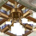 Underneath view showing gold light socket arms and bulbs inside the square frame