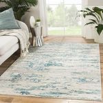 Celil rug laid in bright living room next to sofa and plants, showing scale and room styling
