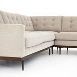 Angled view emphasizing tapered legs and wrap-around wooden framing beneath cushions