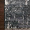 Charcoal and silver modern area rug with abstract textured pattern and fringed edges on dark wood floor