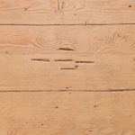 Top-down close-up showing natural wood knots and distressed marks on plank surface