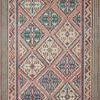 Rectangular bohemian rug with bold geometric diamond patterns in warm coral, blue, green, and cream tones