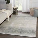 Ombre rug styled in modern living room with sofa, metallic side table, and pouf on dark wood floor