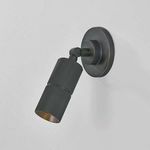 Side view angled downward of distressed bronze knurled cylindrical sconce with visible textured finish