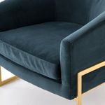 Detailed view of Corbin Chair seat cushion and armrest seams and brass frame edge