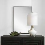 Owen Mirror mounted on wall above dark wooden dresser with lamp and decor
