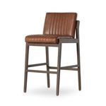 Angled front view showing stool’s vertical channeling and dark brown wood legs