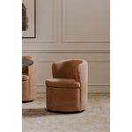 Dane swivel dining chair side angled in a softly lit room with framed wall art