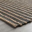 Side view of rug on floor highlighting thickness and rounded braided edges