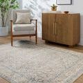 Maria Elena rug styled in a room setting under a mid-century armchair and wooden cabinet