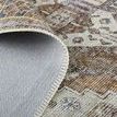 Rolled edge of rug lifted to display back side fabric texture and woven edge binding