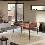Foosball table placed in modern living room with beige rug, natural light, and decorative accents