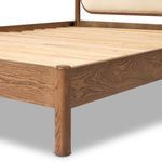 Angle view showing bed frame slats connecting to smoked oak frame beneath upholstered headboard