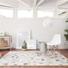 Promenade Grey Rug with hexagonal pattern of light and dark grey cowhide leather, laid on terracotta tile floor in bright ...