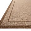 Close-up angled view highlighting the low pile texture and double border detail in warm rust tones