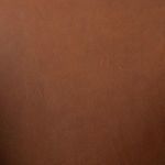 Texture close-up of cognac leather seat showing natural grain
