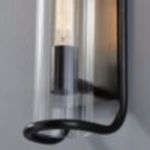 Close-up detail of rounded black metal arm tip and ribbed glass edge with lit bulbs
