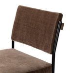 Close-up angled view focusing on brown fabric backrest's smooth texture and black iron supports