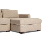 Lower angle close-up of chaise arm and cushion edge with visible fabric texture