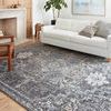 Charcoal and gold rug styled in living room with white sofa, light wood floor, and decorative pillows