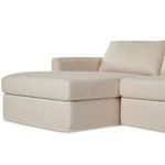 Sectional chaise cushion corner with smooth slipcover and piping detail
