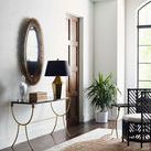 Lucius Mirror hanging on a white wall above a gold frame console table with decor and a black lampshade