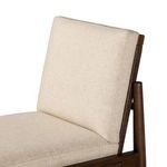 Close-up of padded linen backrest with rattan panels visible behind