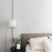 Fleur Premium Matte Wallpaper shown in bedroom setting with bed, pillows, and modern lamp on side table