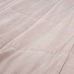 Close-up of the blush cotton fabric and stitching of the Amsterdam Coverlet highlighting the quilted square pattern