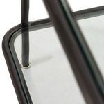 close-up showing the intersection of metal bars and three layers of glass shelf edges