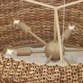 Interior view of chandelier shows beige wrought iron frame and four light bulbs inside