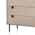 focus on lower right corner of dresser front highlighting black recessed handle and wood texture