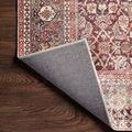 Backside corner of the rug folded over, revealing tightly woven backing in dark gray