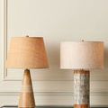 The lamp in a minimalistic room setting on navy shelf next to a taller textured lamp