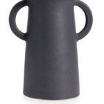 Close-up of the matte black vase’s circular handles and smooth ceramic texture on the base
